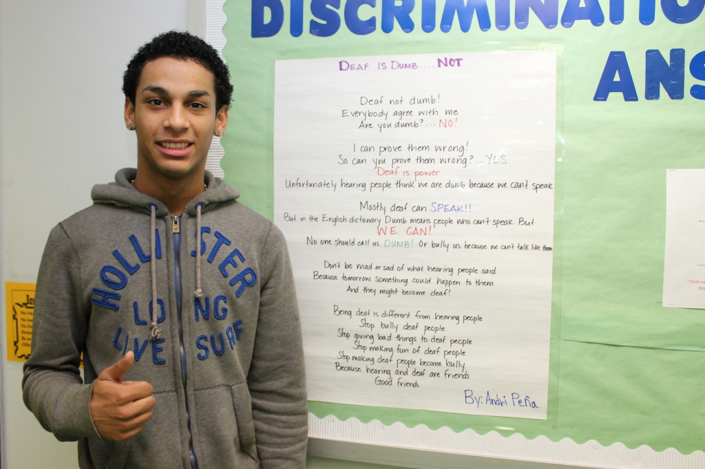 Sophomore Andri Peña stands next to his poem on the 7th floor.