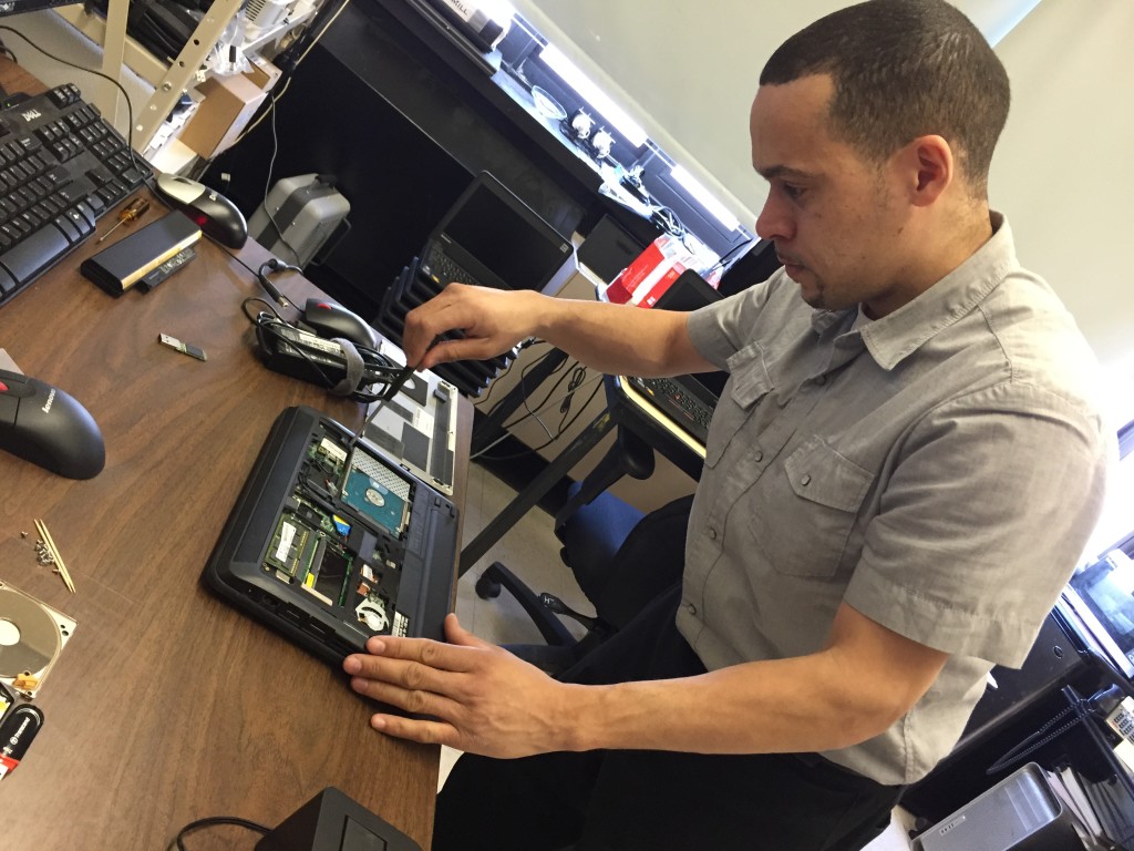 Computer technician Juan Rodriguez gets an inside look at a laptop, to try and figure out what's wrong.