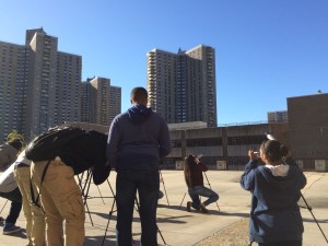 Co-Op City serves as the backdrop as students learn to assemble and use telescopes during their astronomy class.