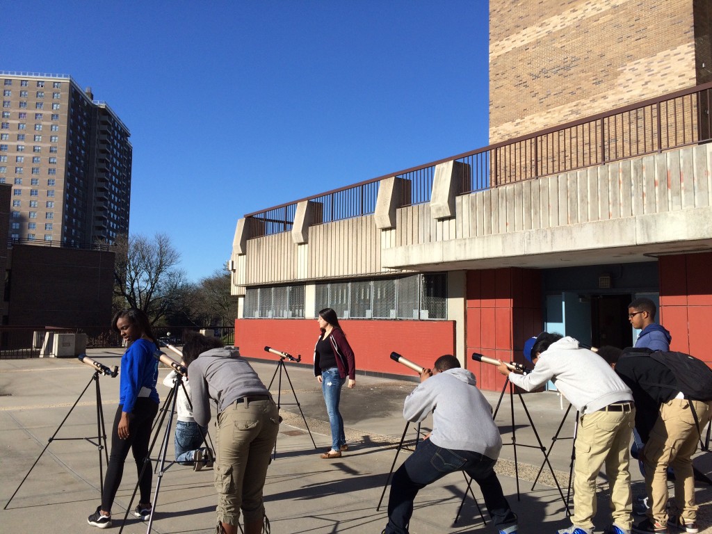 Astronomy Students peer into their newly-assembled telescopes during an early-morning class on Wednesday.