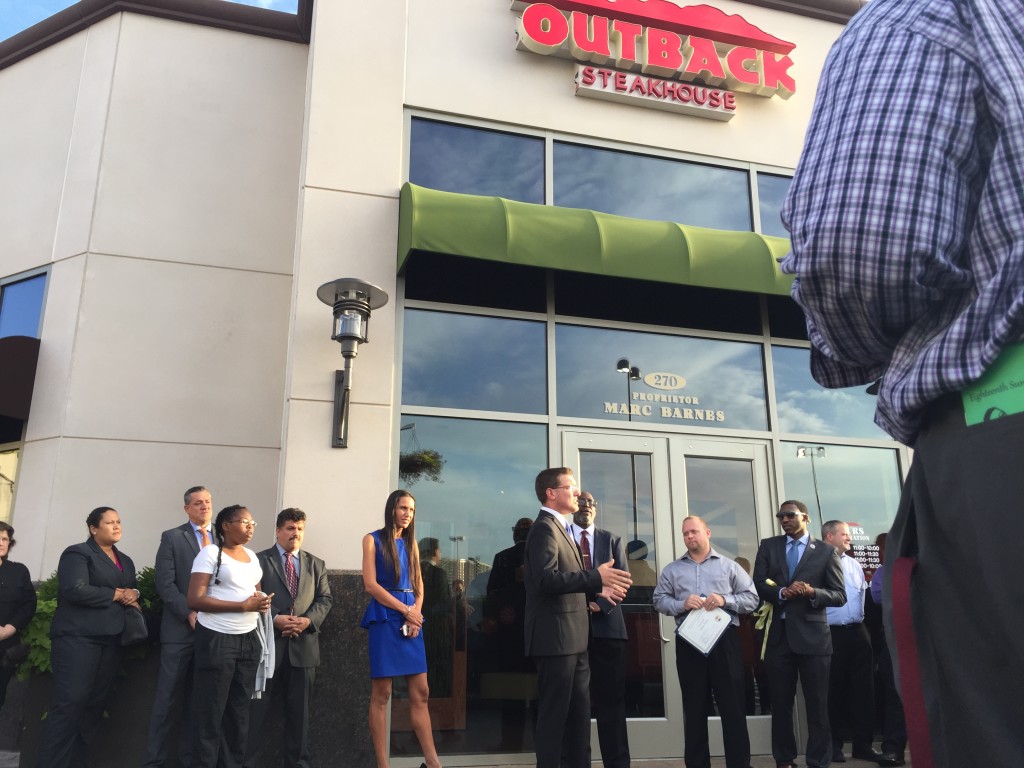 Media Teacher Mr. Roush makes brief remarks outside the new Outback Steakhouse during a ribbon cutting ceremony on Monday. 