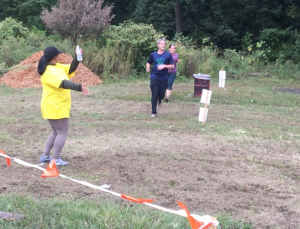 Truman Alumna and Mercy College Sophomore Stephanie Romero dances while she directs runners toward the final obstacle: the mud pits.