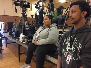 (l to r) Eliza Perez and Abel Zewde wait on the media risers for Hillary Clinton's arrival.